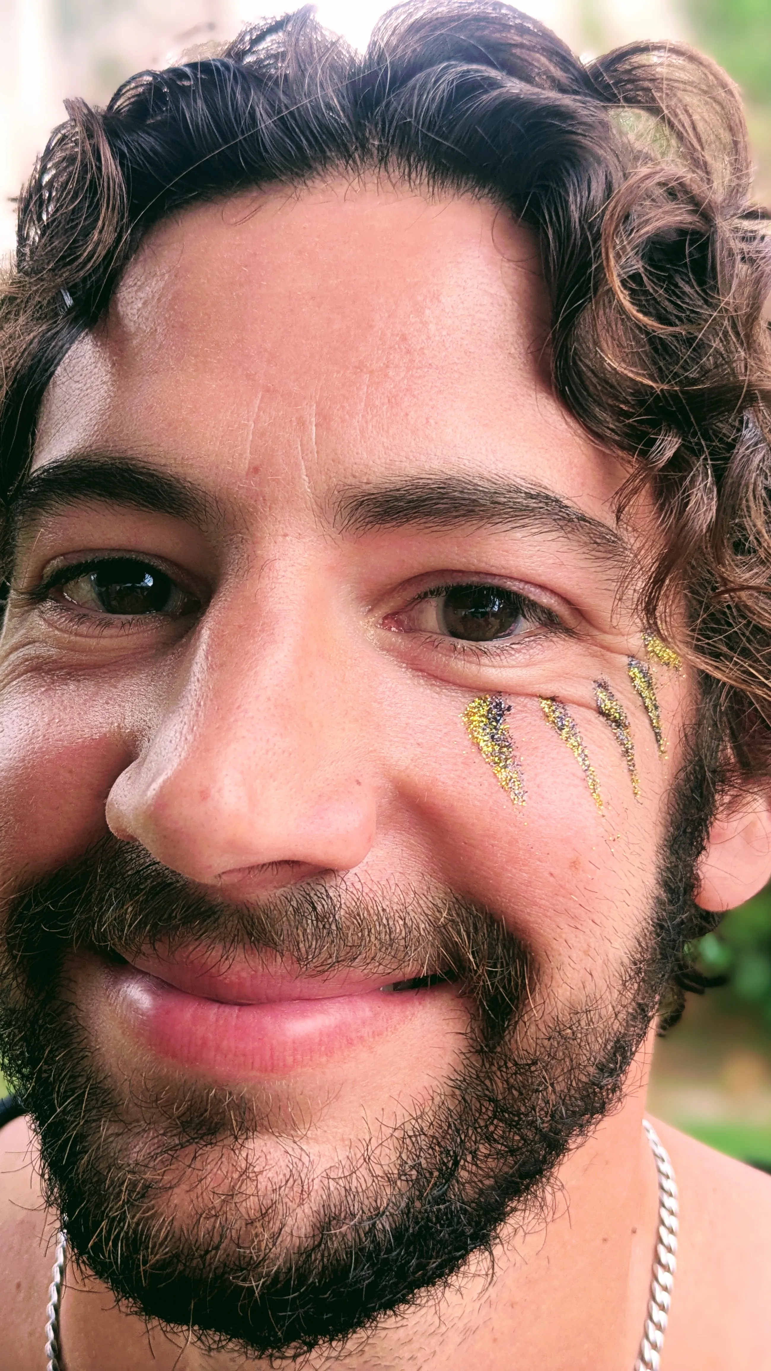 Maquillage paillet&eacute; noir et dor&eacute; graphique sous et au-dessus de l&rsquo;&oelig;il d&rsquo;un homme
